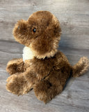 Side angle of a sitting Chocolate Labradoodle weighted stuffed dog with soft pettable fur