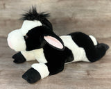 Angled view of a floppy laying weighted Holstein cow plush for sensory comfort and anxiety relief.