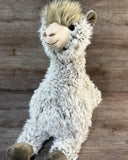 Close-up of jumbo weighted llama stuffed animal with shaggy cream and gray fur, fluffy forehead, friendly smile, and soft brown hooves.