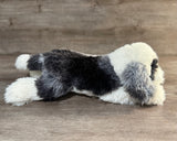 Weighted Sheepadoodle plush laying on its belly, side view
