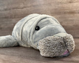 Close-up of the weighted Mama Manatee plush showing its sweet lifelike face, soft whiskers, and plush fabric