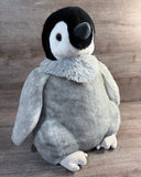 Side-angled view of 20-inch weighted penguin plush showing its soft gray rounded body, fluffy neck, and long floppy wing.