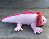 Side profile of 19-inch pink weighted axolotl stuffed animal showing its long, low-profile body, fluffy gills, and soft unweighted legs.